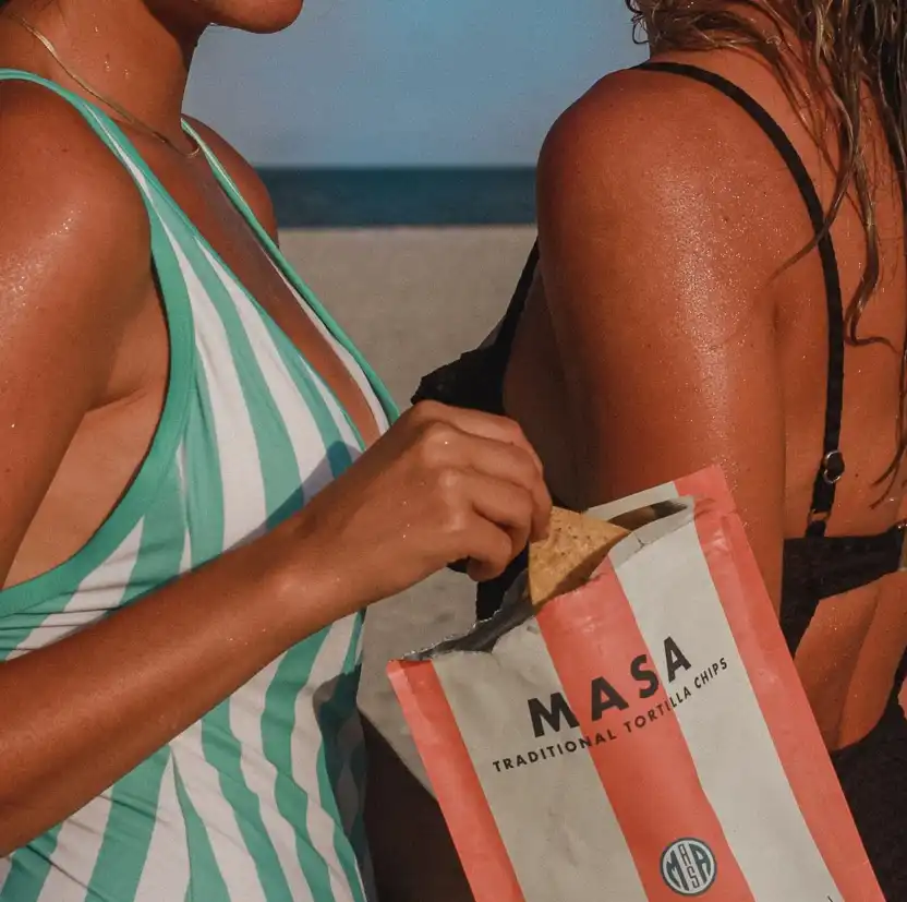 Girl in swimsuit holding a MASA Chips bag