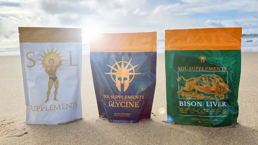 Three products from Sol Supplements lined up next to each other on a beach